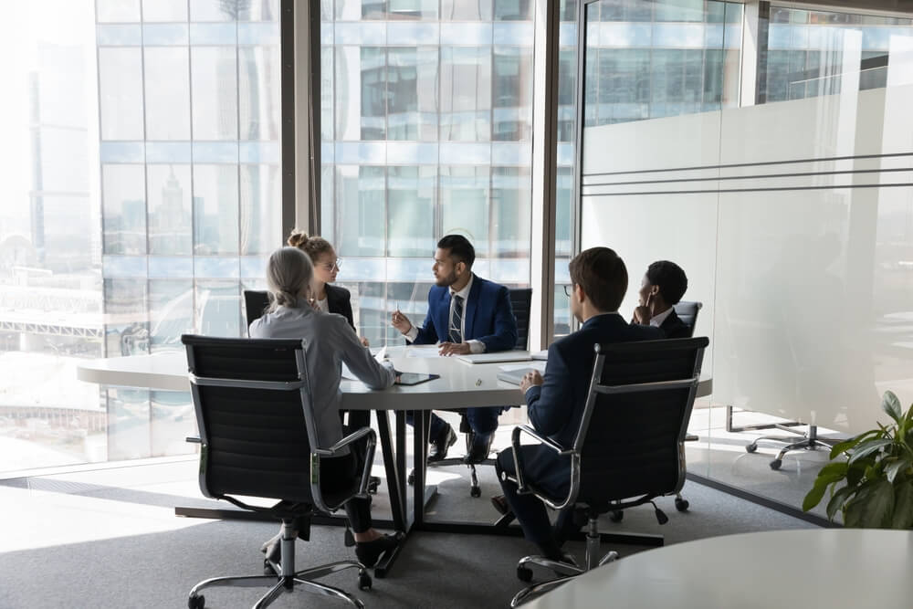 Reunião de empresários numa mesa redonda, simbolizando tipos de empresas no Brasil