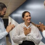 Três funcionários da GR Assessoria Contábil e Tributária sorriem em um ambiente de trabalho positivo e acolhedor.